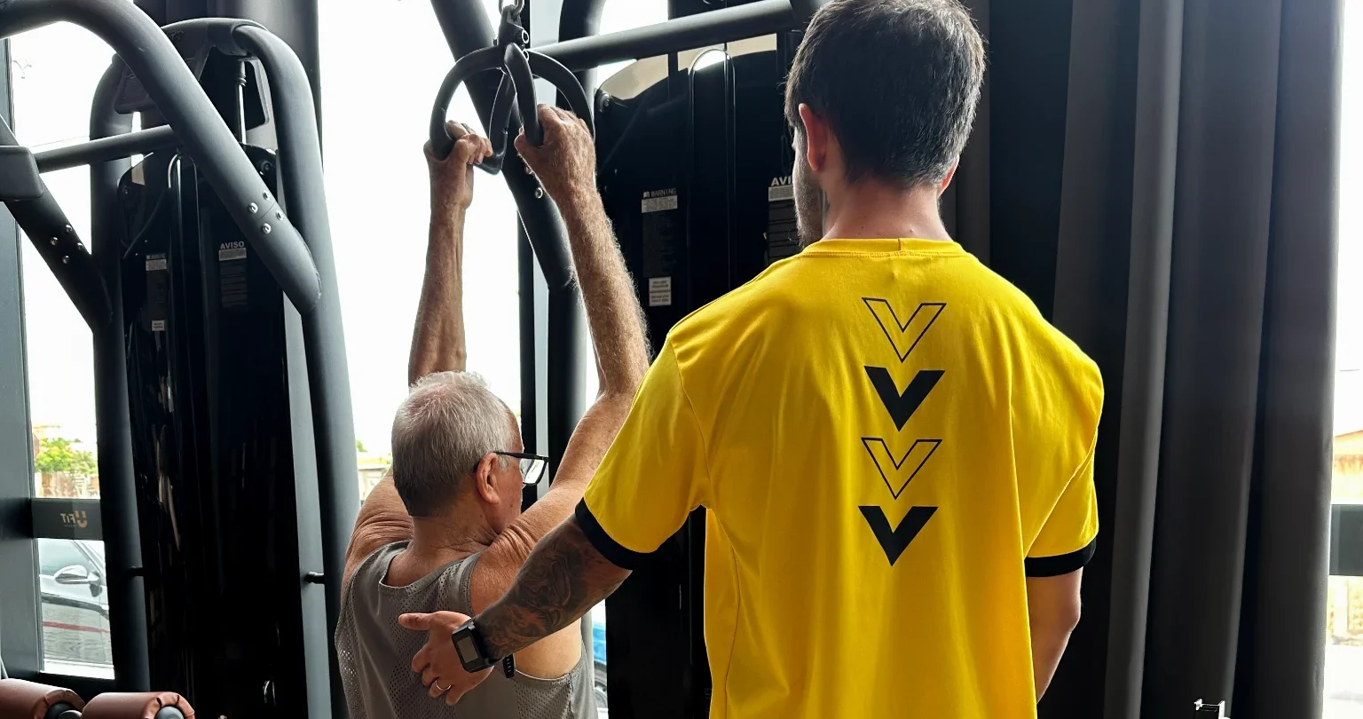 Professor orientando aluno na máquina