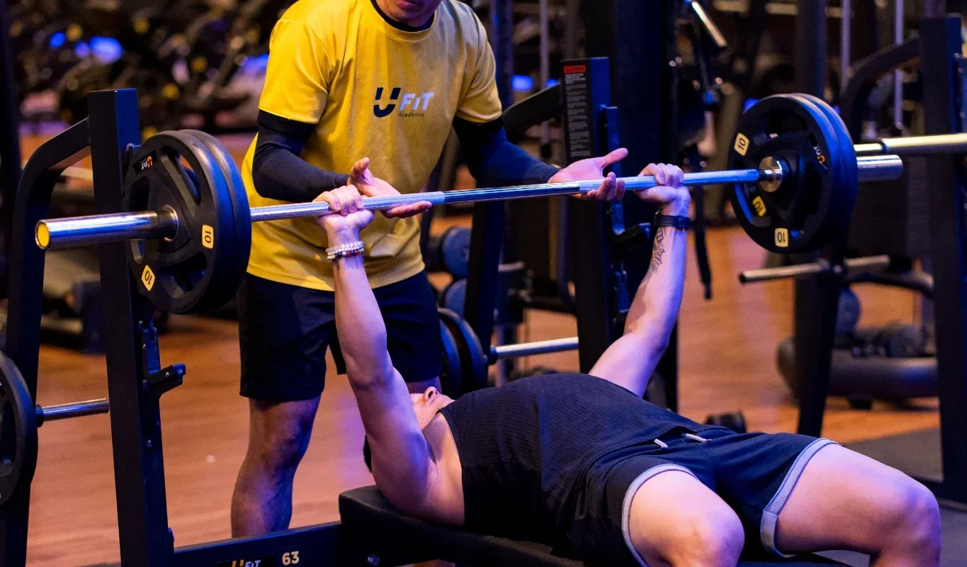 Aluno treinando supino na UFit